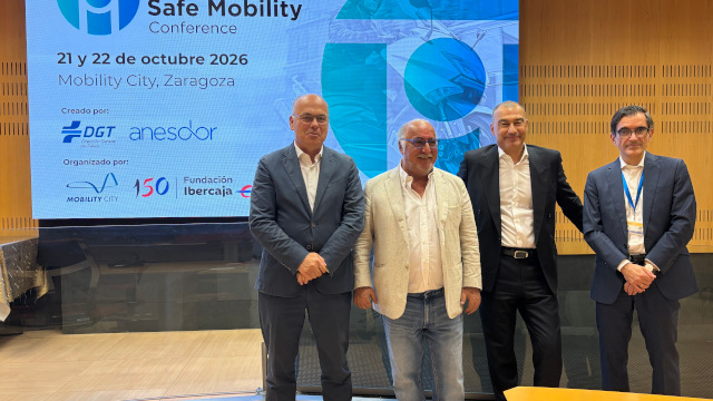 Cuatro personas posan ante la pantalla de presentación de la International Motorcycle Safe Mobility Conference 2026 en Zaragoza.