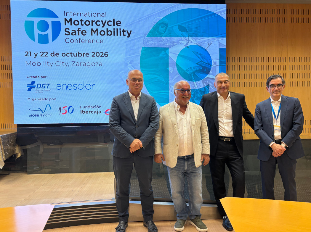 Cuatro personas posan ante la pantalla de presentación de la International Motorcycle Safe Mobility Conference 2026 en Zaragoza.