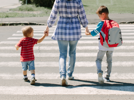 Madre cogiendo de la mano a sus hijos, pasando paso de peatones