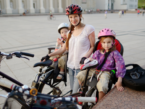 Madre de paseo con sus hijos en bici