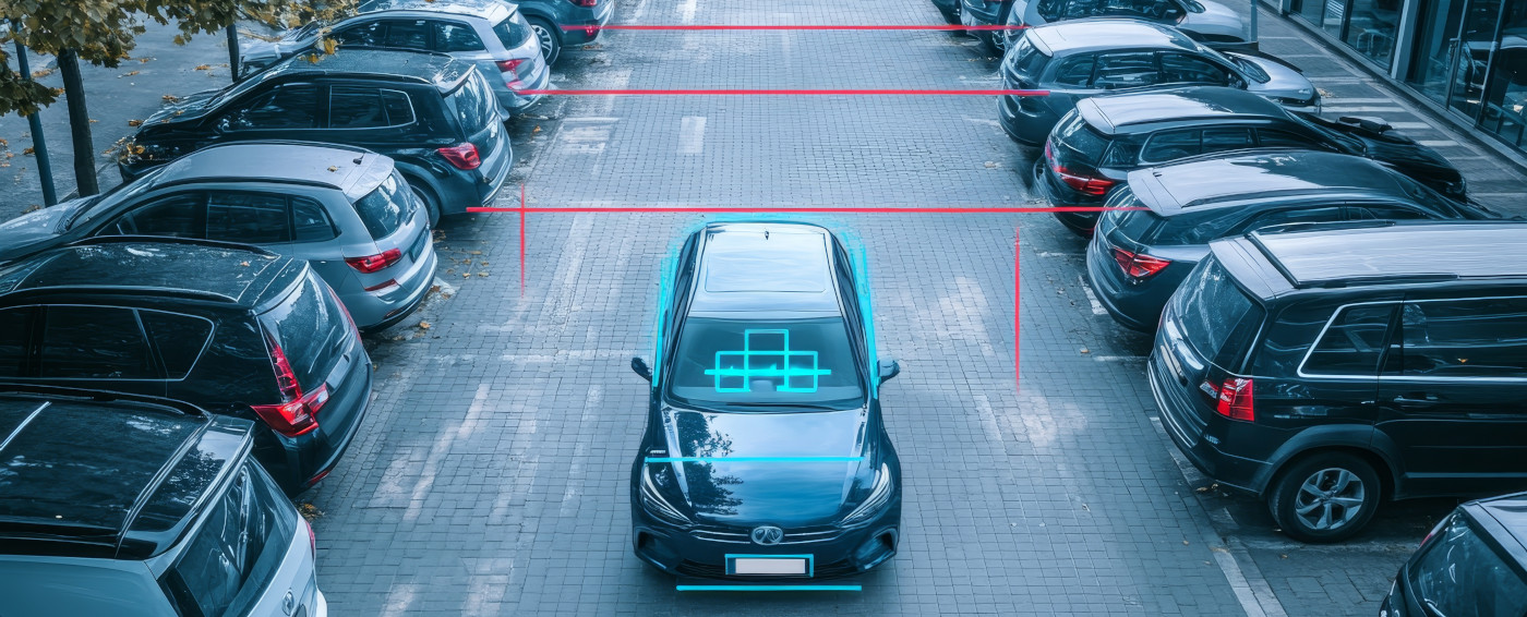 Vehículo circulando entre dos hileras de coches aparcados en batería y una línea roja en la parte superior del coche midiendo la distancia entre las hileras