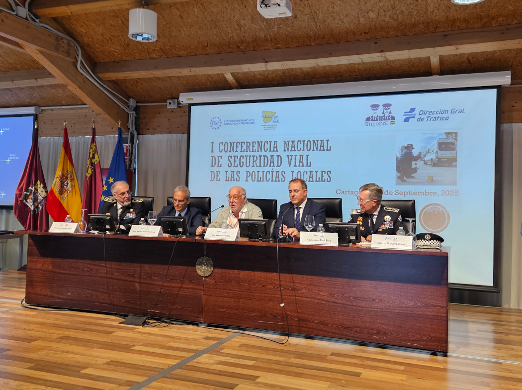 Mesa inaugural de la I Conferencia Nacional de Seguridad Vial de las Policías Locales en Cartagena, con cinco ponentes uniformados y autoridades sentados frente a un cartel proyectado con el título del evento