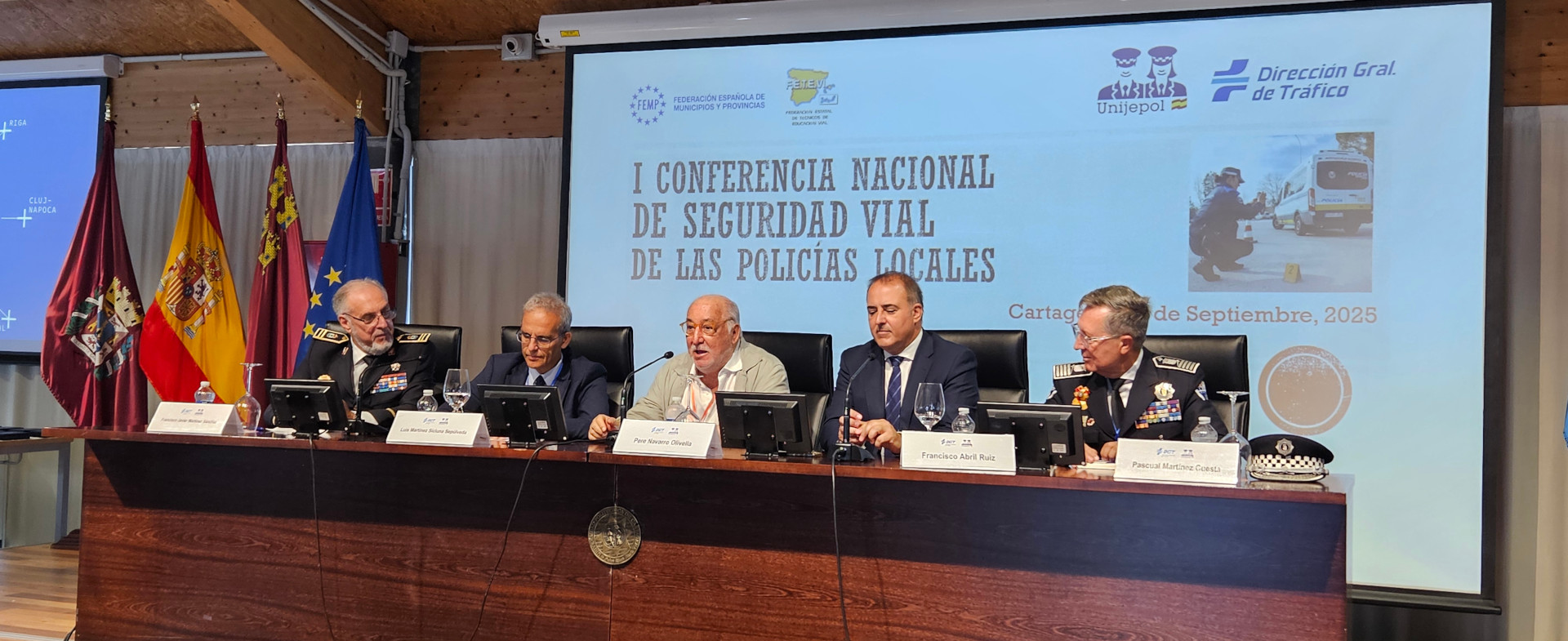 Mesa inaugural de la I Conferencia Nacional de Seguridad Vial de las Policías Locales en Cartagena, con cinco ponentes uniformados y autoridades sentados frente a un cartel proyectado con el título del evento