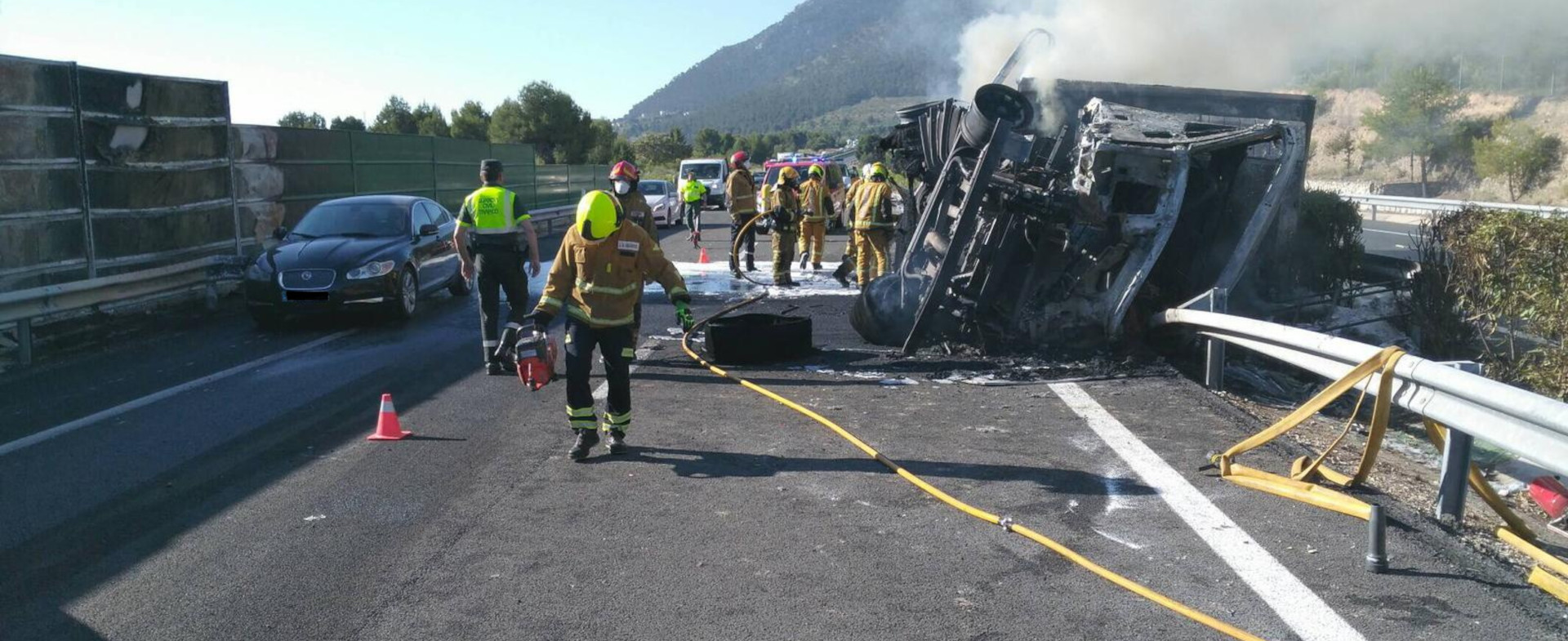 Dispositivo de bomberos atendiendo un accidente de tráfico de un camión