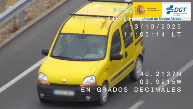 Vehículo amarillo captado por una cámara de seguridad con el logotipo en la esquina superior derecha de la Dirección General de Tráfico y el Ministerio del Interior