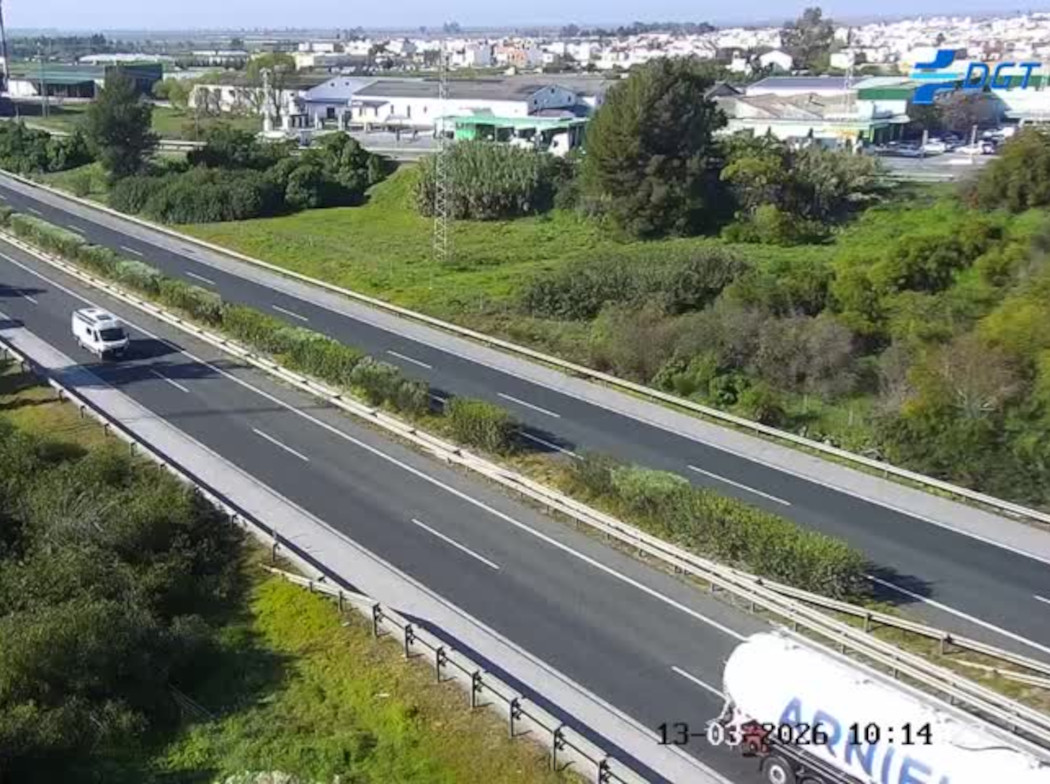 Imagen de una autovía en la que circulan un cocho y un camión, rodeada de vegetación.