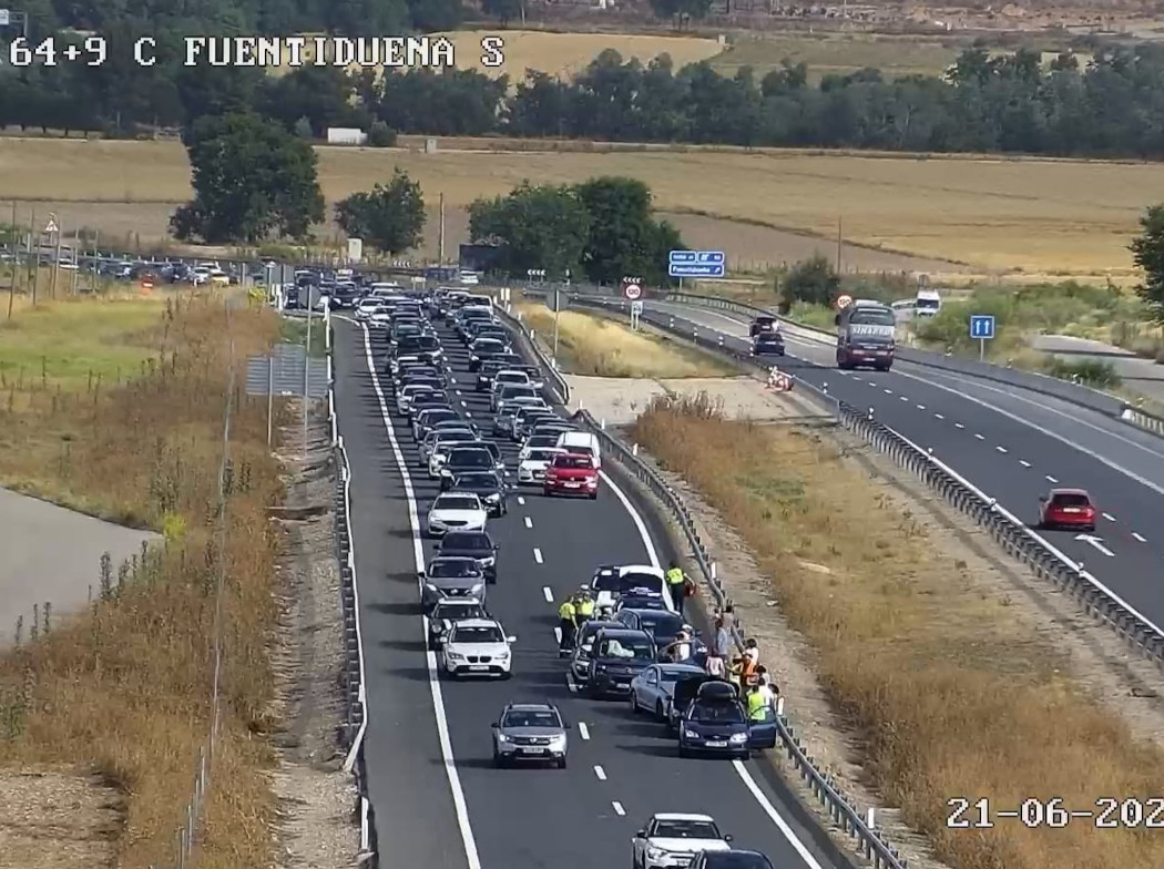 Autopista con vehículos circulando y un vehículo accidentado en el carril de la derecha.