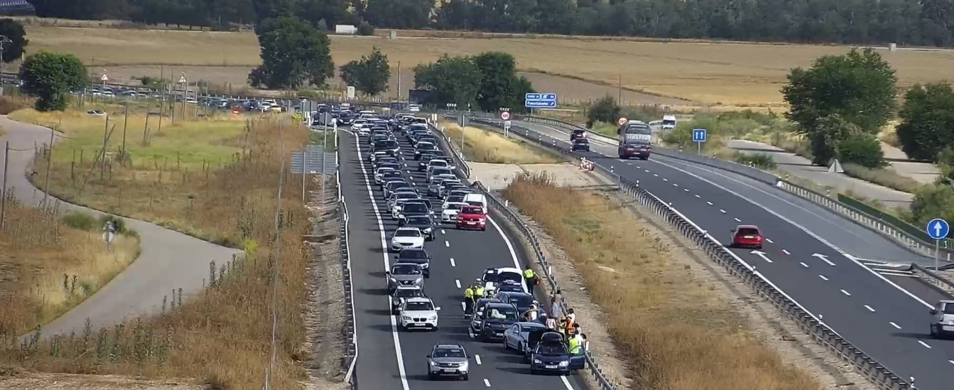 Autopista con vehículos circulando y un vehículo accidentado en el carril de la derecha.