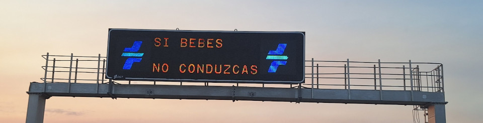 Panel de información luminoso en una autopista con el slogan 'Si bebes, no conduzcas' y los logos de la DGT.