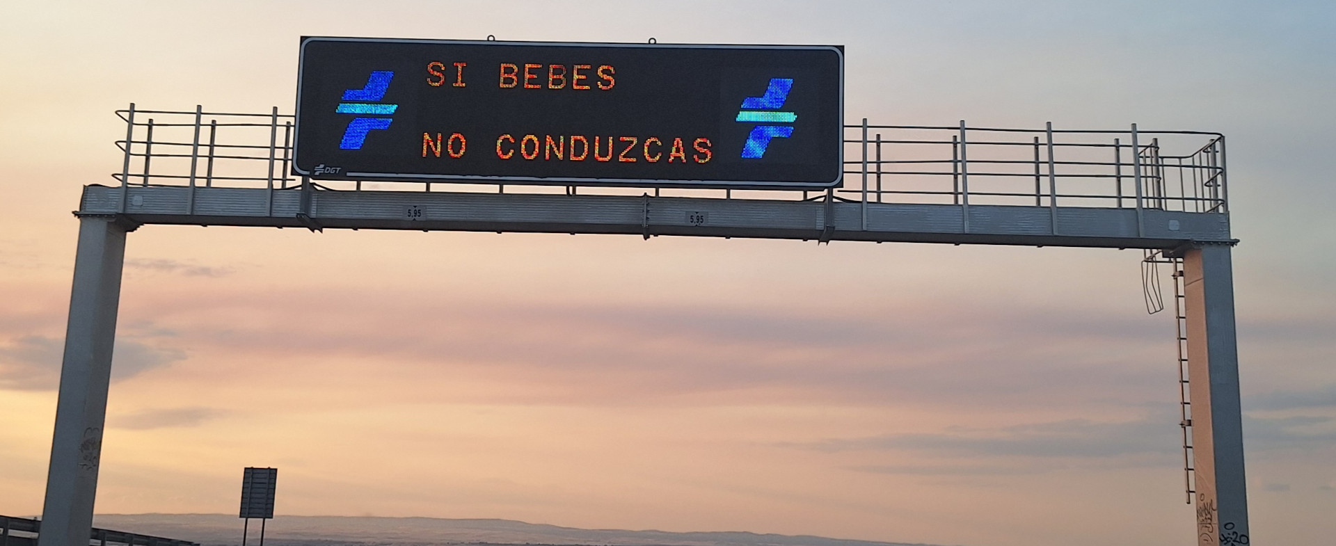 Panel de información luminoso en una autopista con el slogan 'Si bebes, no conduzcas' y los logos de la DGT.