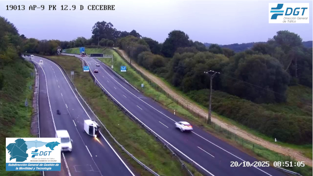 Autovía de dos carriles con coches circulando y una furgoneta volcada que bloquea uno de ellos