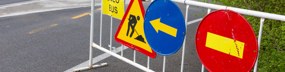 Vaya metálica en una autopista con diferentes señales de tráfico de obras colgadas