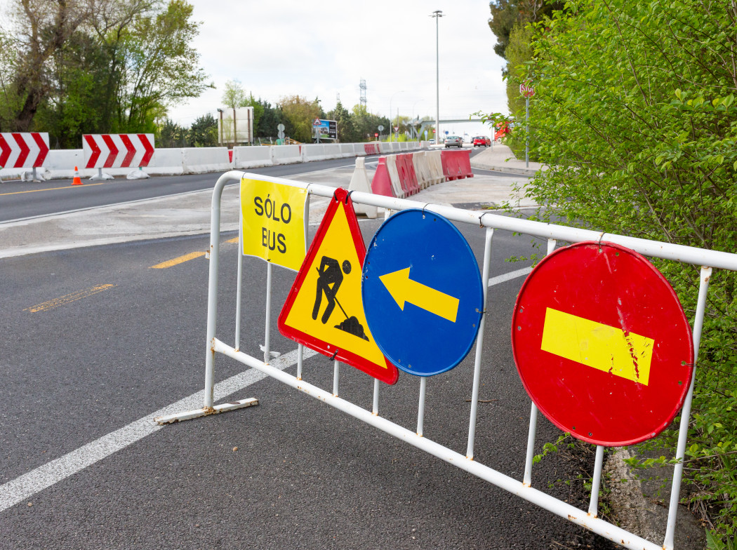 Vaya metálica en una autopista con diferentes señales de tráfico de obras colgadas