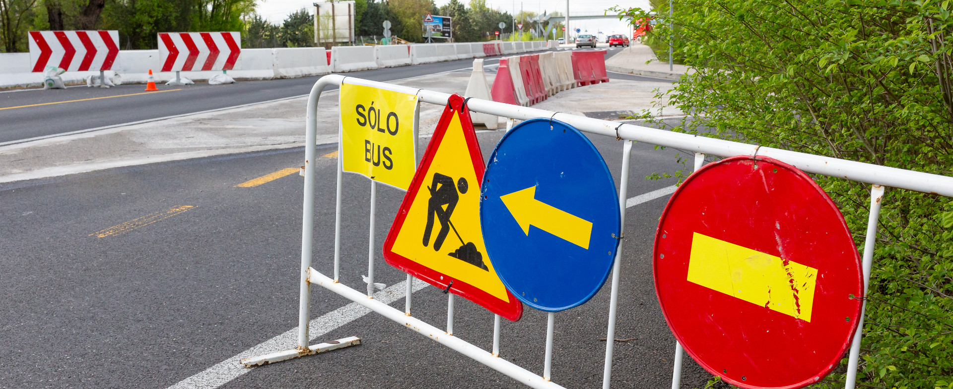 Vaya metálica en una autopista con diferentes señales de tráfico de obras colgadas