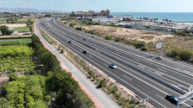 Imagen aérea de una autovía de costa con vehículos circulando con la playa de fondo.