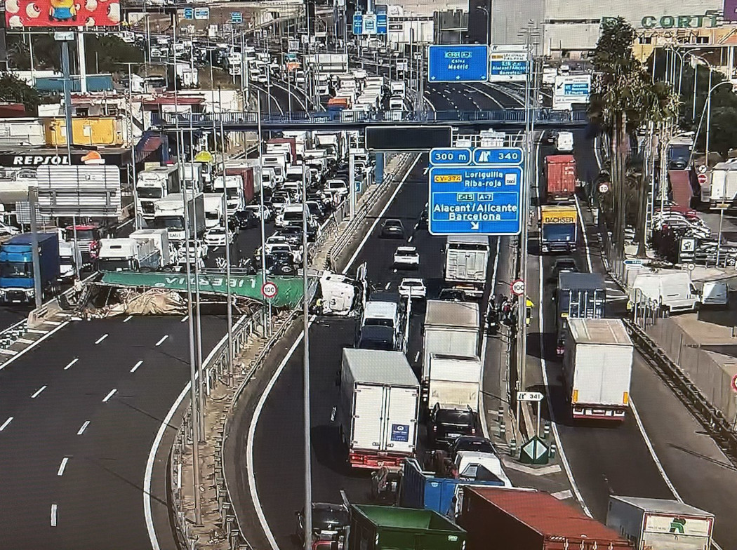 Autovía de Alicante de varios carriles transitada por vehículos. Entre dos de las vías hay un camión siniestrado en horizontal ocupando varios carriles.