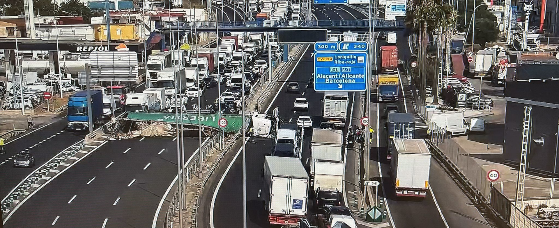 Autovía de Alicante de varios carriles transitada por vehículos. Entre dos de las vías hay un camión siniestrado en horizontal ocupando varios carriles.