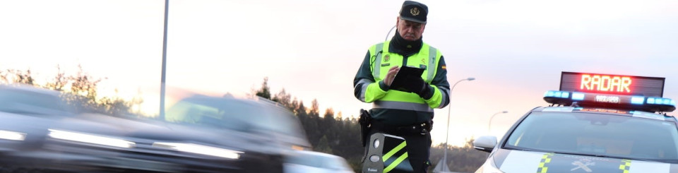 Agente de la Guardia Civil de Tráfico junto a un radar móvil
