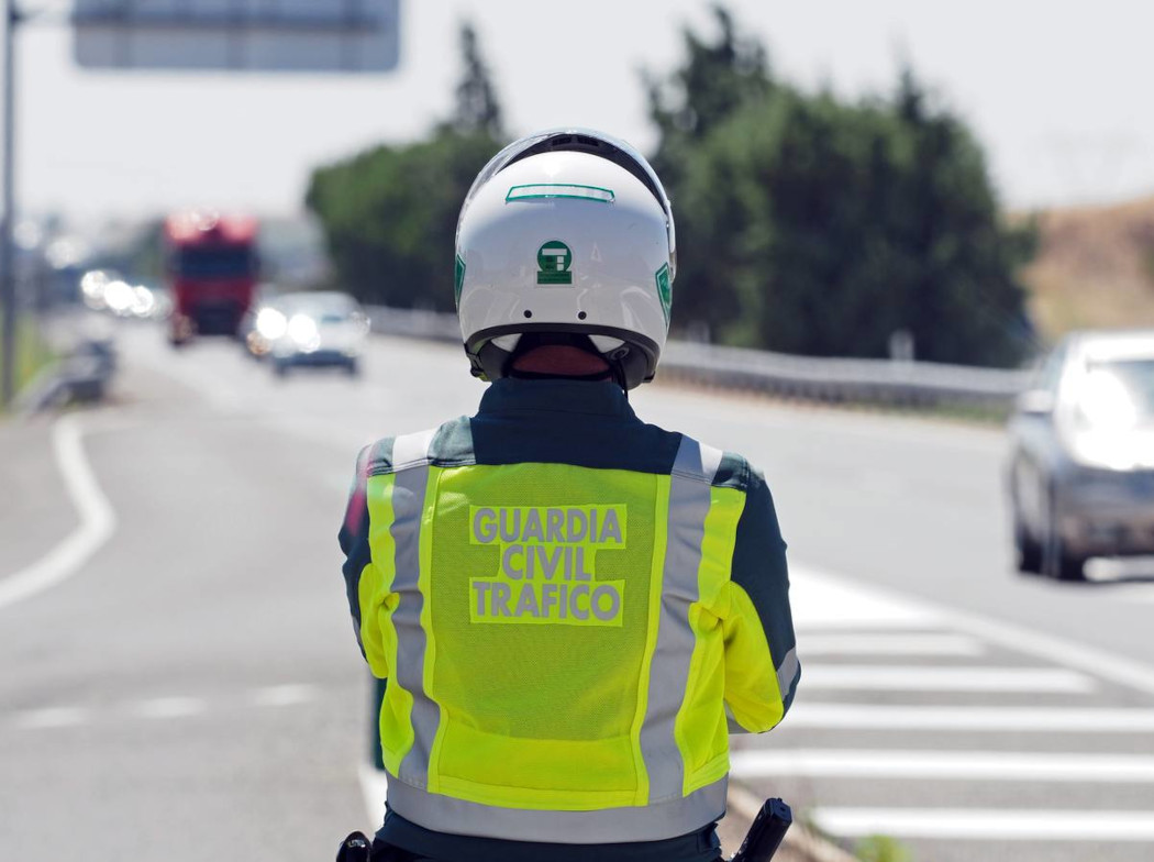 Agente de la Guardia Civil de espaldas observando una autopista.