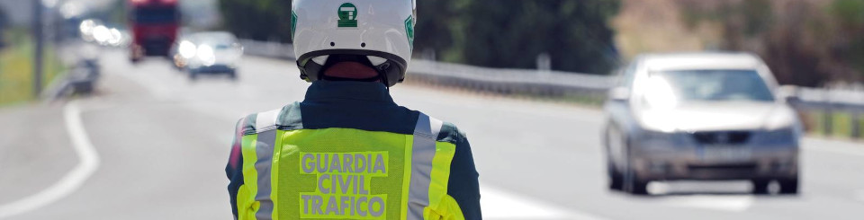 Vista de espaldas de un Guardia civil de tráfico observando una autopista