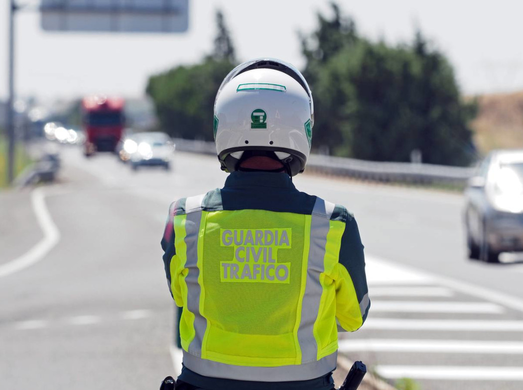 Vista de espaldas de un Guardia civil de tráfico observando una autopista