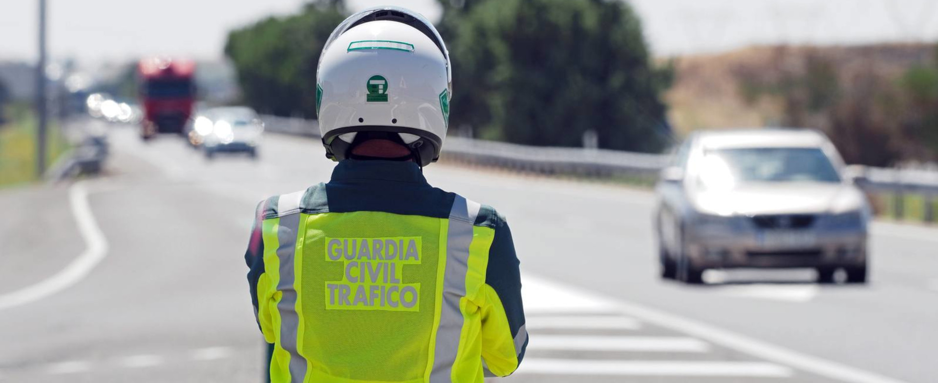 Vista de espaldas de un Guardia civil de tráfico observando una autopista