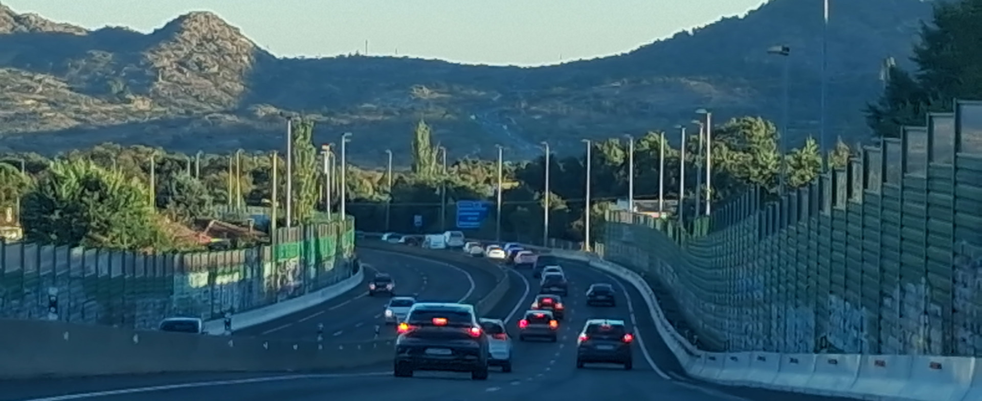 Autopista con vehículos circulando con montaña al fondo