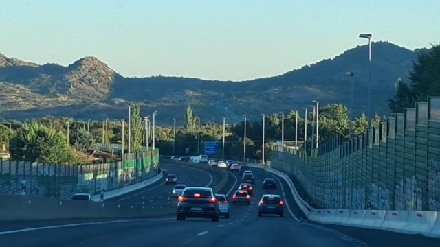 Autopista con vehículos circulando con montaña al fondo