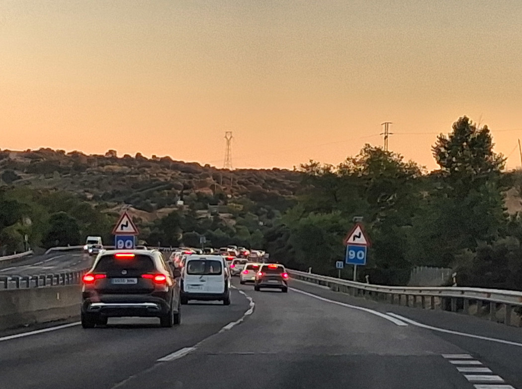 Vehículos circulando por una autopista al atardecer