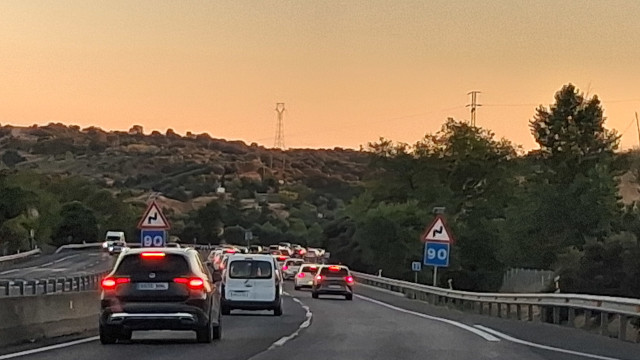 Vehículos circulando por una autopista al atardecer