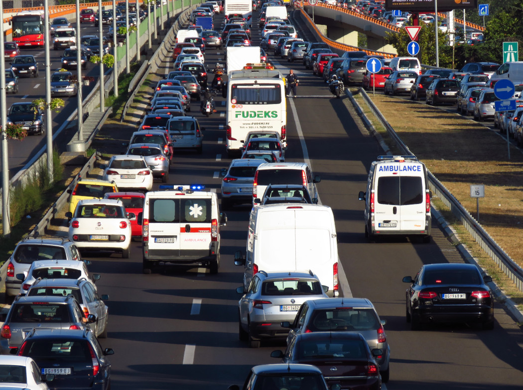 Autopista con coches atascados y ambulancia circulando por carril de la derecha