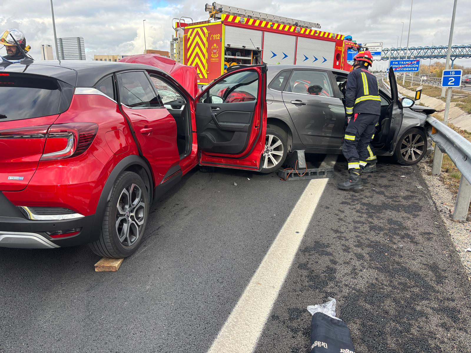 Bombero socorriendo en un accidente de tráfico entre dos vehículos