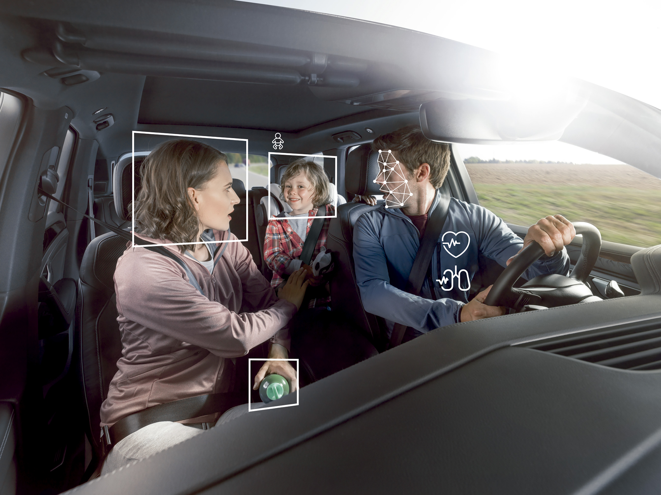 Interior de coche con un sistema de IA monitorizando a tres pasajeros. Recuadros blancos identifican el rostro de la copiloto, un niño en el asiento trasero y la cara del conductor. Iconos técnicos muestran la monitorización de constantes vitales del conductor y la detección de un objeto en la mano de la copiloto.