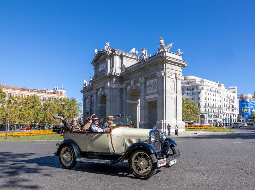 Tres hombres montados en un vehículo histórico descapotable en Madrid