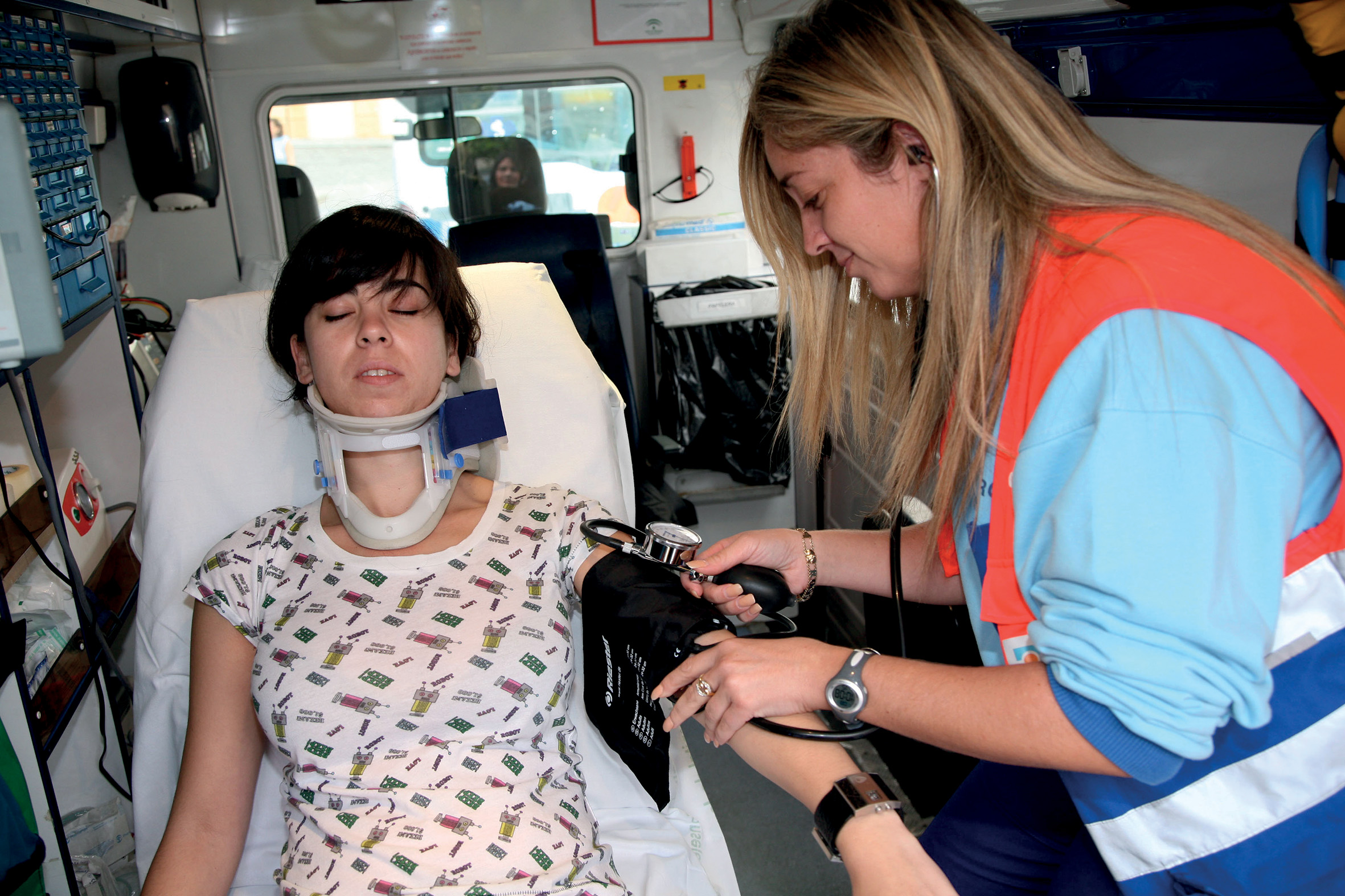 Mujer dentro de una ambulancia con un collarín y atendida por una sanitaria