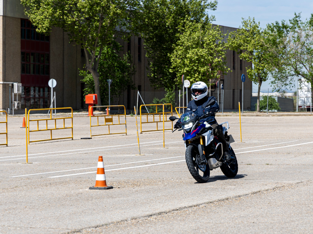 Moto con piloto en un circuito de pruebas con conos.