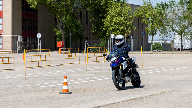 Moto con piloto en un circuito de pruebas con conos.