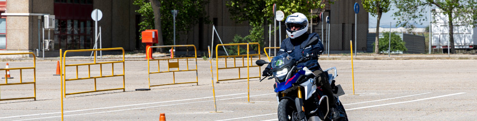 Moto con piloto en un circuito de pruebas con conos.