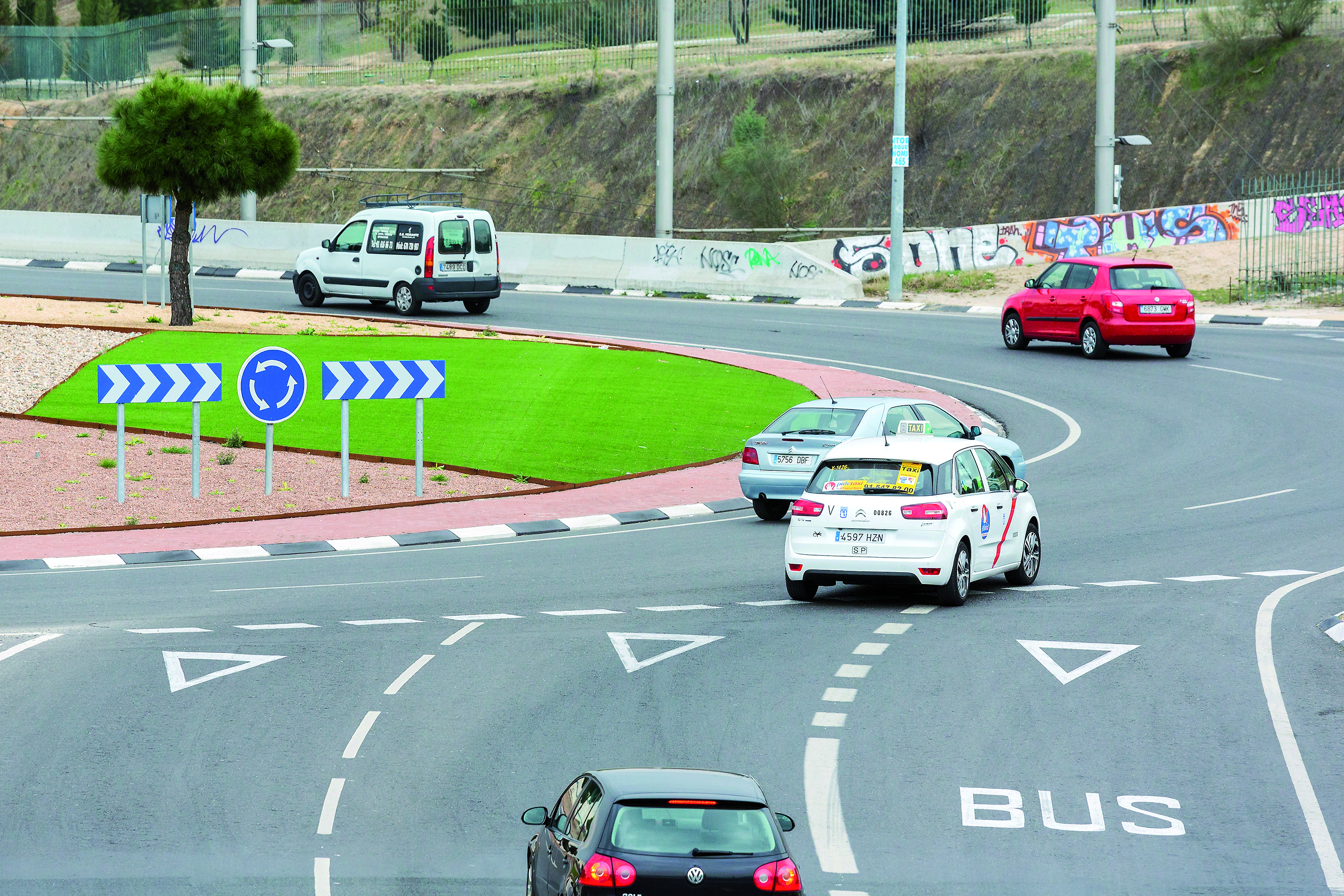 Vista parcial de la entrada a una glorieta, con tres carriles de acceso