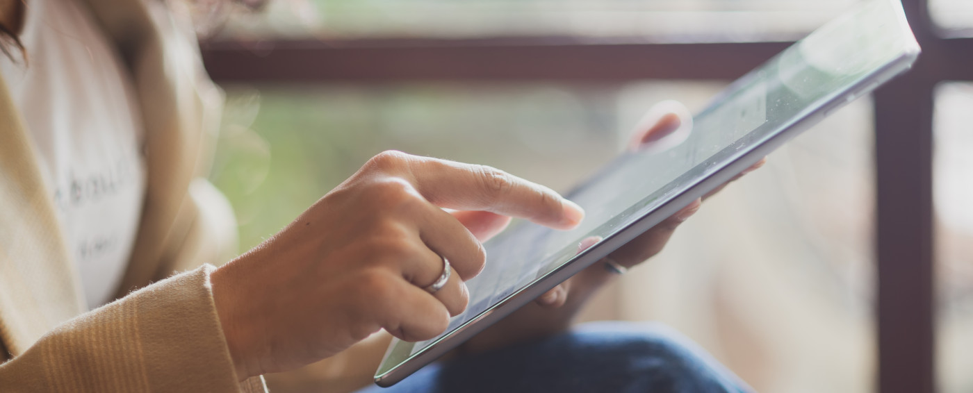 Mano de mujer seleccionando con el dedo índice en una tablet.