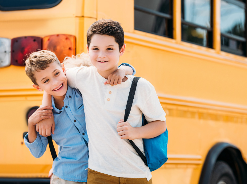 Niños delante de un autobús escolar