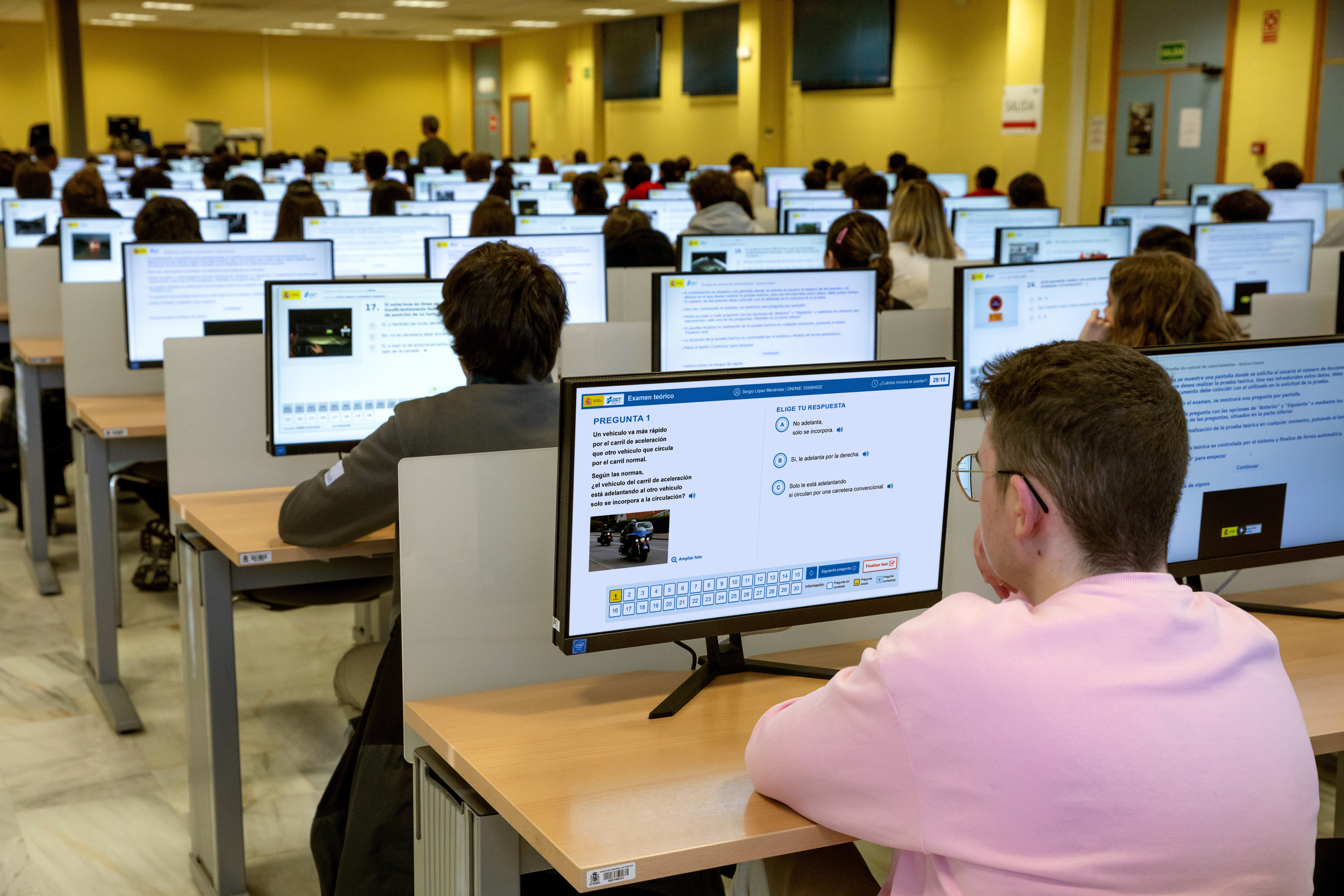 Aula de exámenes de la DGT con personas haciendo el examen delante del ordenador