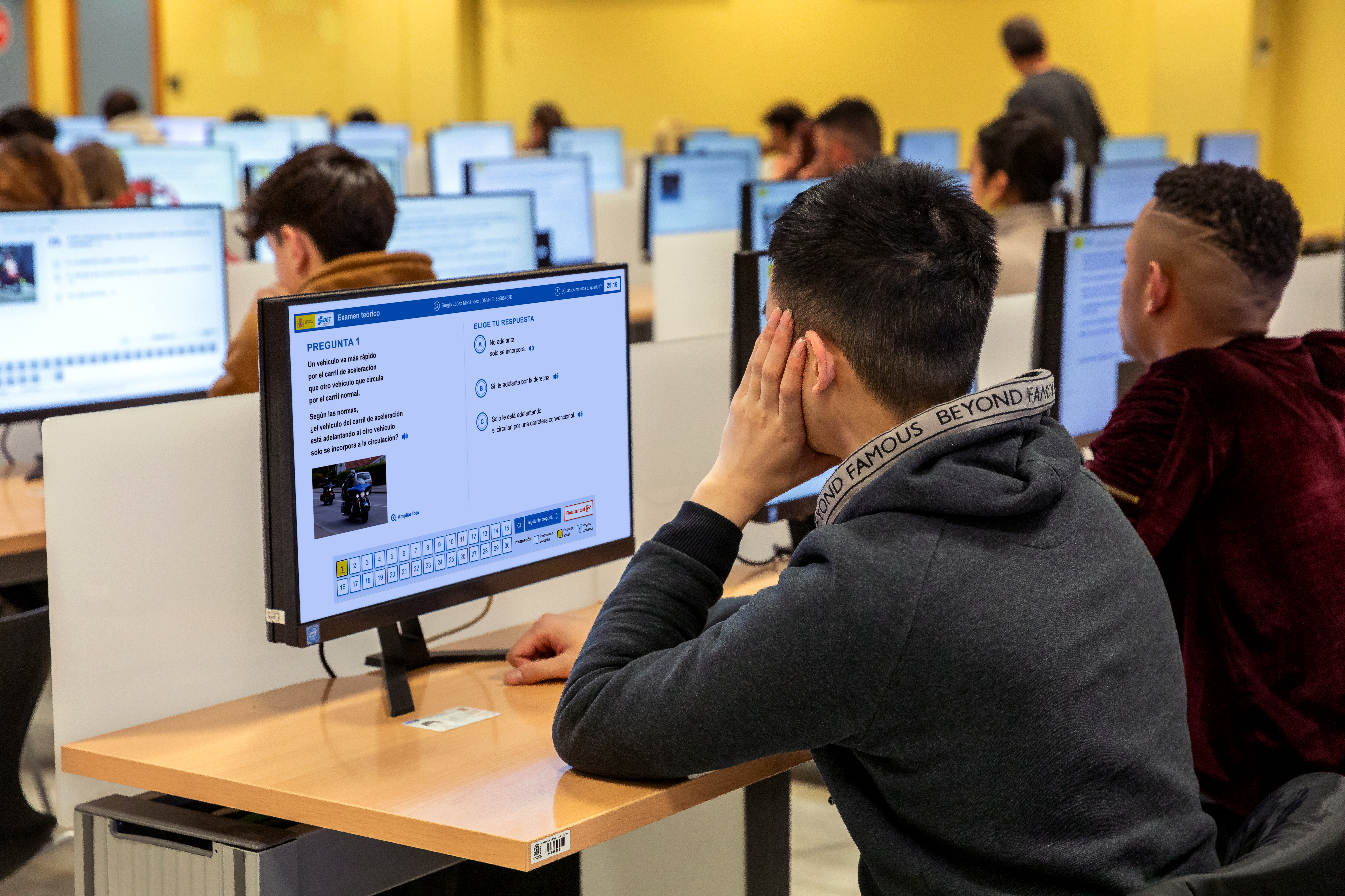 Aula de exámenes de la DGT con personas haciendo el examen delante del ordenador